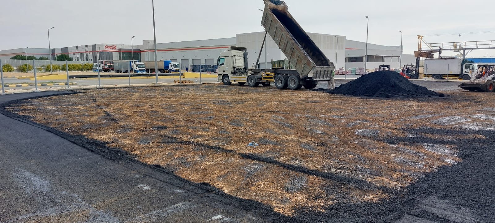 Tipper truck discharging hot asphalt for the base course on a prepared sub-grade