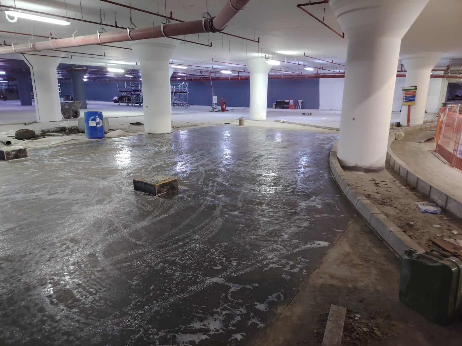 Concrete being poured and levelled on a commercial slab